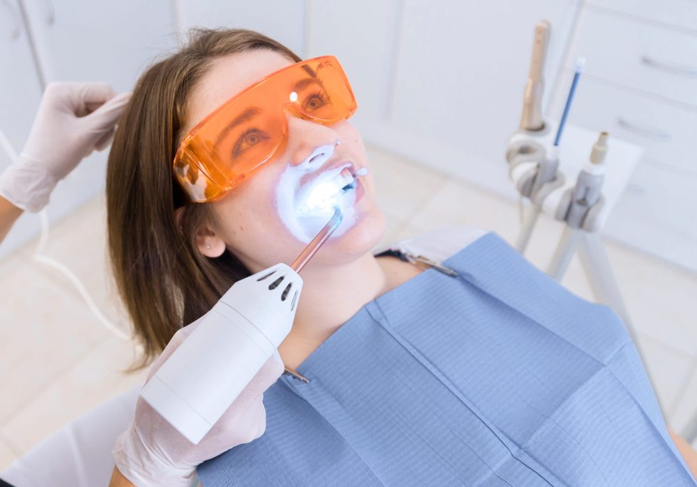 dentist-examining-patient-s-teeth-with-dental-uv-light-equipment (1)